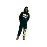 A person wears a black Sp5der Jeffery hoodie and matching sweatpants with bold yellow text and star graphic prints.