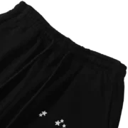 Close-up view of the elastic waistband detail on the black Sp5der Jeffery streetwear sweatpants with logo.