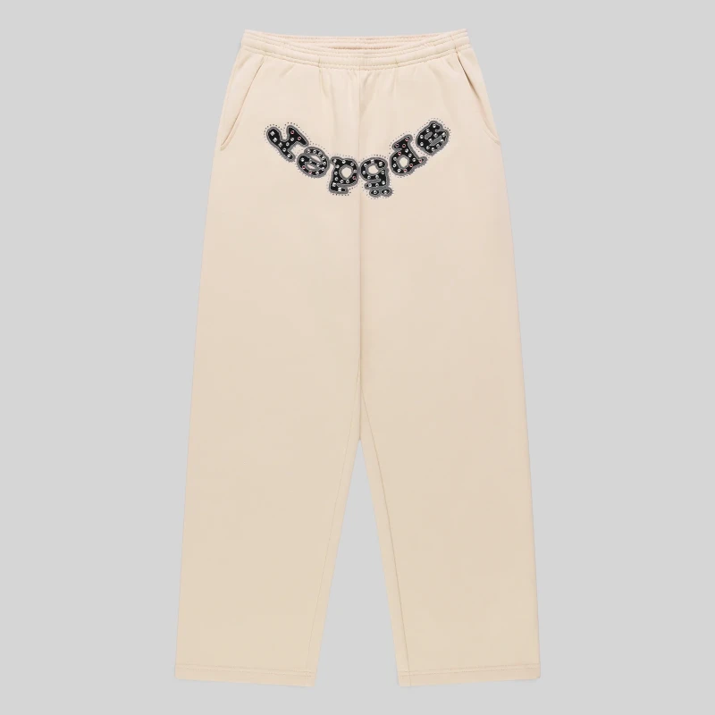 Front view of Sp5der Mixed Stone OG V2 cream sweatpants made from 13oz premium cotton fleece with studded logo detail.