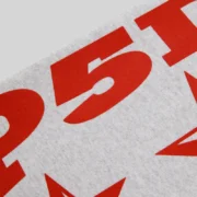 Close-up view of the bold red graphic print on the Heather Grey Sp5der Mx555 zip hoodie fleece fabric.