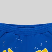 Detailed closeup of the vibrant blue Sp5der OG logo sweatshorts featuring white star graphics and elastic waistband.