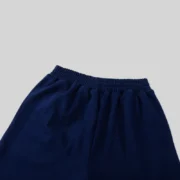 Close-up view of the elastic waistband on a pair of navy blue Sp5der OG Web Logo sweat shorts for a comfortable fit.