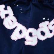 Close-up view of the Sp5der OG Web Logo on Navy Blue sweat shorts featuring iconic star graphic print details.