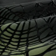 Close-up view of the Sp5der OG Web Ombre Hoodie in black showing the textured black puff print web graphic on fabric.