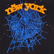 Close-up graphic print detail on the black Sp5der OG Web V2 Knicks Alternate Hoodie featuring a blue spider web design.