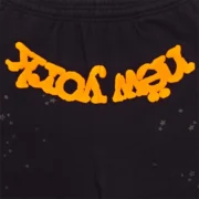 Close-up of Sp5der OG Web V2 Knicks Alternate sweatpants in black with orange graphic print and scattered star details.