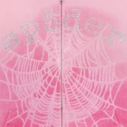 Close-up view of the Sp5der OG Web V2 Spray Zip Hoodie in light pink featuring rhinestone detailing and a web print.