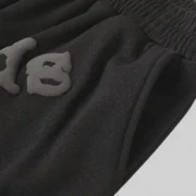 A close-up detail view of the black Sp5der OG Web V2 sweatshorts featuring the signature graphic print on the front.