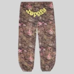 Front view of Sp5der OG Web sweatpants in a brown Real Tree camo pattern with pink flowers and yellow Sp5der branding.