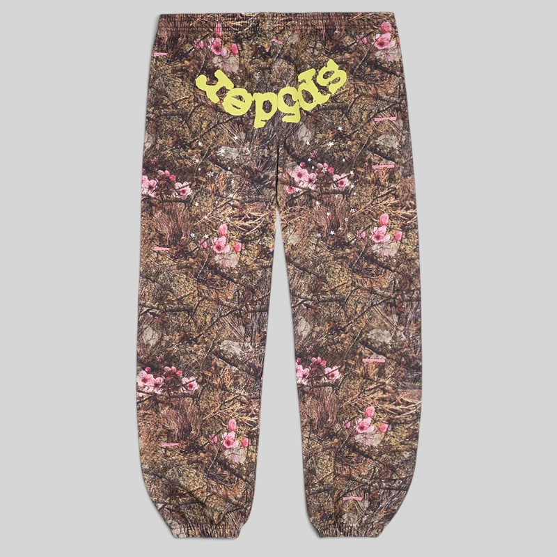 Front view of Sp5der OG Web sweatpants in a brown Real Tree camo pattern with pink flowers and yellow Sp5der branding.