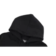 Close-up view of the hood on a premium Sp5der P*NK black unisex hoodie showing quality fabric and branding details.