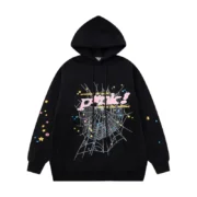 Front view of the black Sp5der P*NK hoodie featuring a spider web design and colorful star graphics on the fabric.