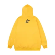 Back view of the vibrant mustard-yellow Sp5der P*NK collaboration hoodie featuring signature urban streetwear branding.