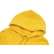 Close-up view of the vibrant mustard-yellow hood of the limited edition Sp5der P*NK collaboration designer hoodie.