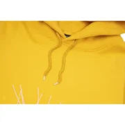 Close-up view of the vibrant mustard-yellow Sp5der P*NK collaboration hoodie showing the high-quality fabric texture.