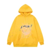 Front view of the Sp5der P*NK collaboration hoodie in a vibrant mustard-yellow colorway with graphic web print.