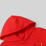 Closeup detail of the vibrant red Sp5der P*NK V2 Hoodie showing the premium heavyweight cotton fleece fabric texture.