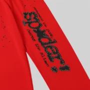 Close-up view of the Sp5der P*NK V2 sweatpants in red, featuring signature black puff print graphics and star details.