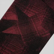 Closeup view of the black Sp5der Plaid Splatt hoodie fabric showing the detailed cotton fleece texture and pattern