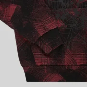 Close-up view of the black and red plaid fabric and graphic web print on the Sp5der Plaid Splatt Hoodie Black.