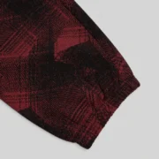 Close-up view of the premium cotton fleece fabric and black plaid print detail on Sp5der Plaid Splatt Sweatpants.
