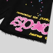 Close up of the Sp5der Black Punk V2 Sweatshorts showing the signature pink graphic print and scattered star design.