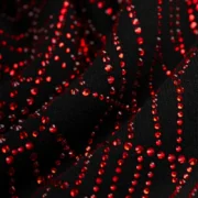 Detailed closeup of the black Sp5der Rhinestone OG Web V2 Hoodie featuring a red rhinestone web graphic print.