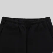 Close-up view of the elasticized waistband on the Sp5der Rhinestone Script Sweatpants in classic black cotton fleece.