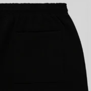 A detailed close-up shot of the pocket area on the black Sp5der Rhinestone Silk sweatpants for street fashion wear.