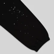 Close-up view of the black Sp5der Rhinestone Silk sweatpants featuring scattered premium rhinestone detailing.