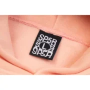 Close-up view of the interior neck tag detail on the Sp5der SP5 Bellini Hoodie in baby-pink, featuring size L branding.