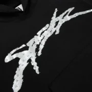 Close-up view of the Sp5der Screaming Eagle Hoodie in black, featuring signature SP5DER logo with rhinestone accents.