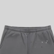 A detailed close-up of the grey Sp5der Splat Punk sweatpants showing the elastic waistband and star graphic print.