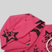 Close-up view of the black stencil graphic print on the pink Sp5der Stencil Hoodie from the exclusive FW25 collection.