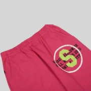 Close-up view of the pink Sp5der Stencil sweatpants showing the signature graphic print detail and vibrant fabric.