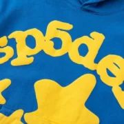 Close-up of the Sp5der Beluga Hoodie in TC Blue featuring iconic yellow puff print logo and star design on the front.