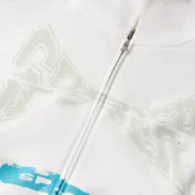 Close-up view of the Sp5der T&F Zip Up Hoodie in White showing the detailed front graphic print and zipper closure.
