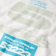 Close-up view of the white Sp5der T&F Zip Up Hoodie featuring bold graphic puff prints and scattered star detailing.