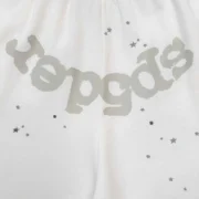 Close-up view of the white Sp5der T&F sweatshorts featuring signature puff print graphic detailing and star accents.
