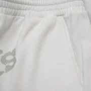Closeup of white Sp5der T&F fleece sweatshorts showing high-quality fabric texture and signature graphic print detail.