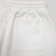 Close-up view of the premium heavyweight white cotton fleece fabric on the Sp5der T&F Sweatshorts back pocket detail.