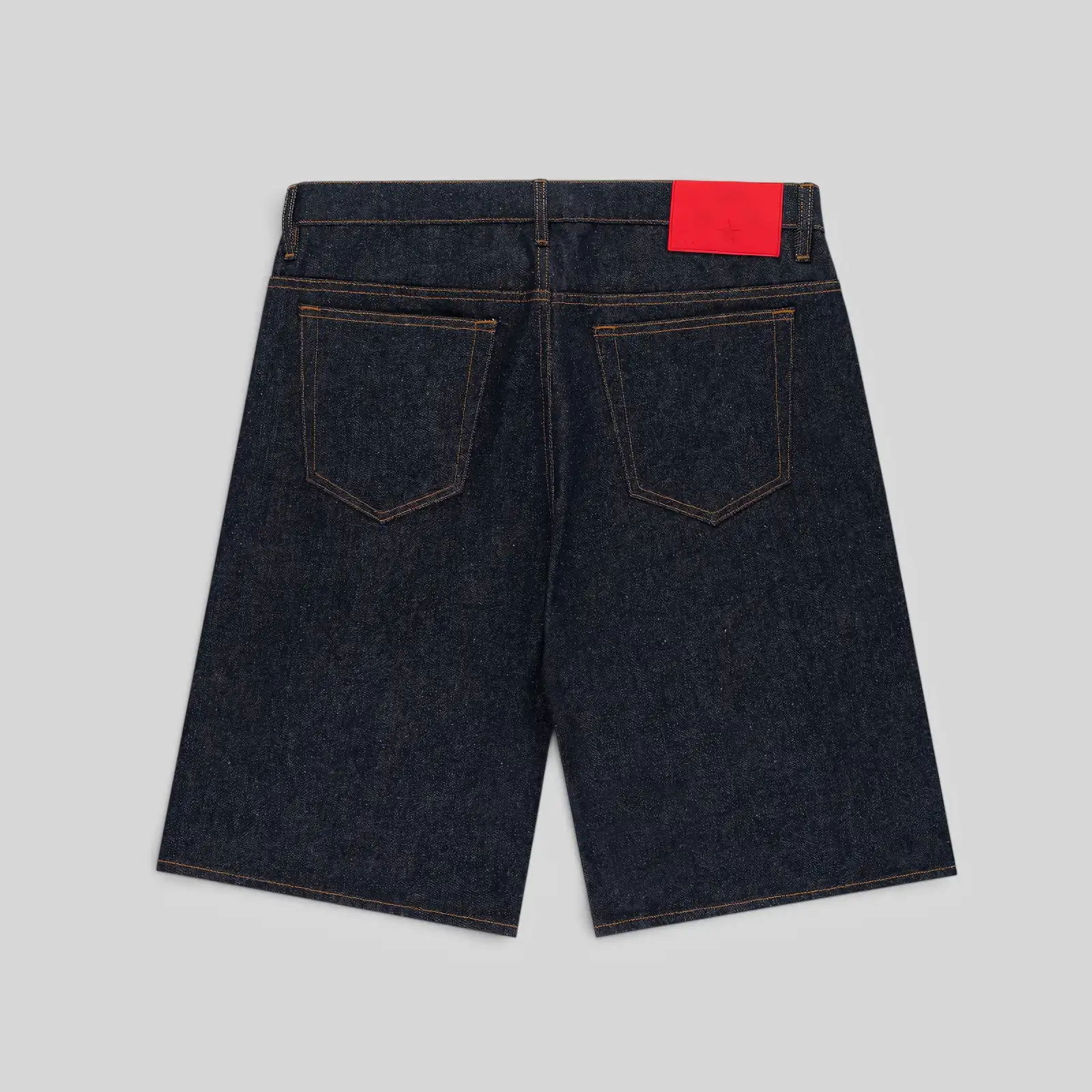 Back view of Sp5der V3 Logo Indigo Denim Shorts featuring a branded red leather patch on the back waistband.