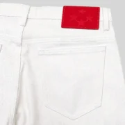 Close-up view of the Sp5der V3 Logo Denim Shorts in white featuring a premium red leather branded patch on the back.