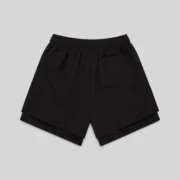 Back view of the black Sp5der VAA double-layer technical shorts featuring a patch pocket and elasticized waistband.