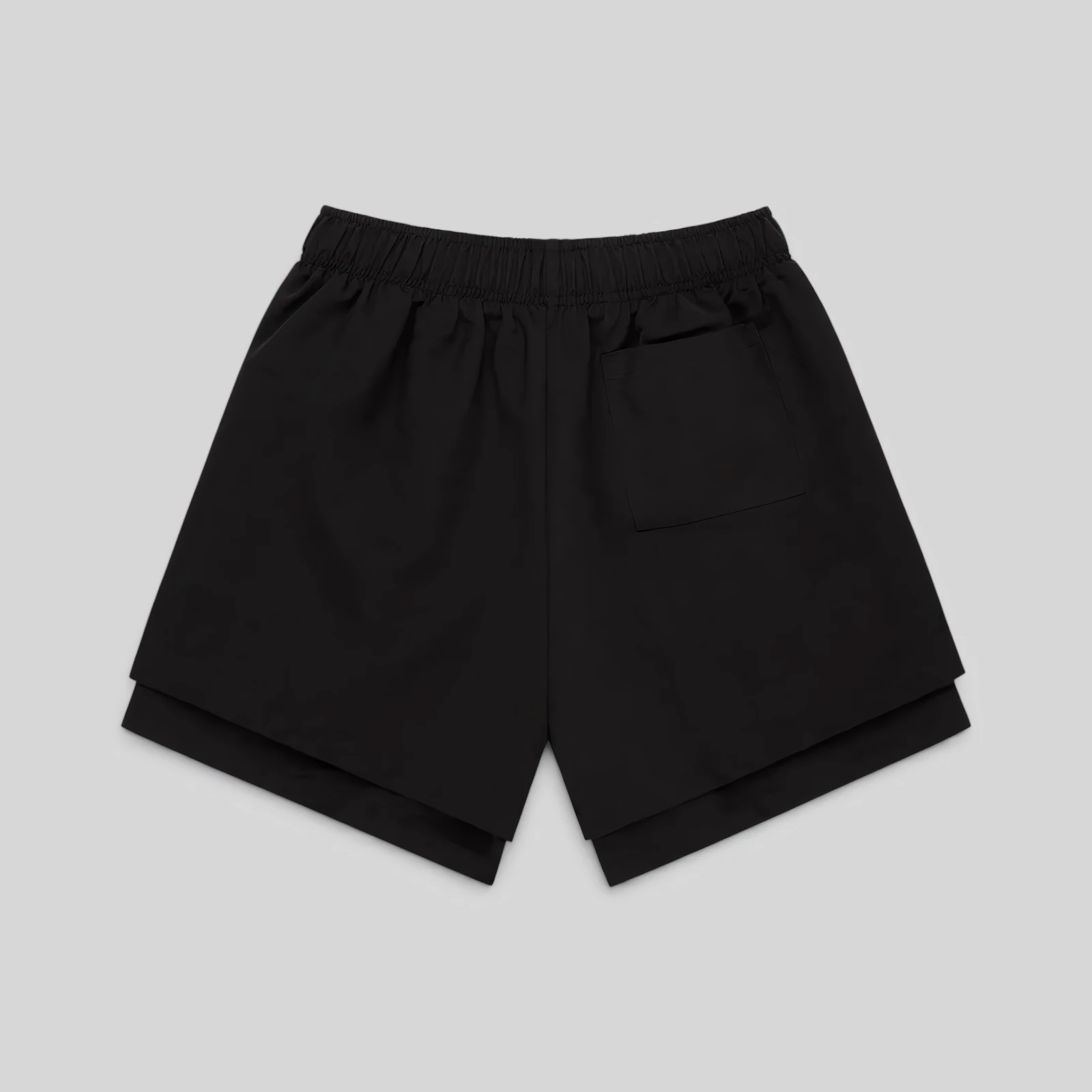 Back view of the black Sp5der VAA double-layer technical shorts featuring a patch pocket and elasticized waistband.
