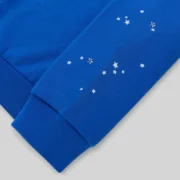 Close-up of the Sp5der Varsity Web Crewneck in blue, highlighting the sleeve with its signature scattered star print.