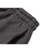 Close-up view of the elasticated waistband on the premium Sp5der Wait Web Sweatpant in a sophisticated slate-green color.