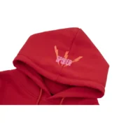 Close-up view of the hood on a red Sp5der Worldwide Angel Number 555 hoodie featuring signature branding detail.