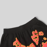 Detailed close-up of the Sp5der x UY Scuti sweatshorts in black with high-contrast red collaborative graphic branding