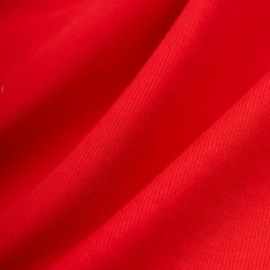 Close-up view of the red 100% cotton fabric texture from the Sp5der Araignée Tee streetwear collection.